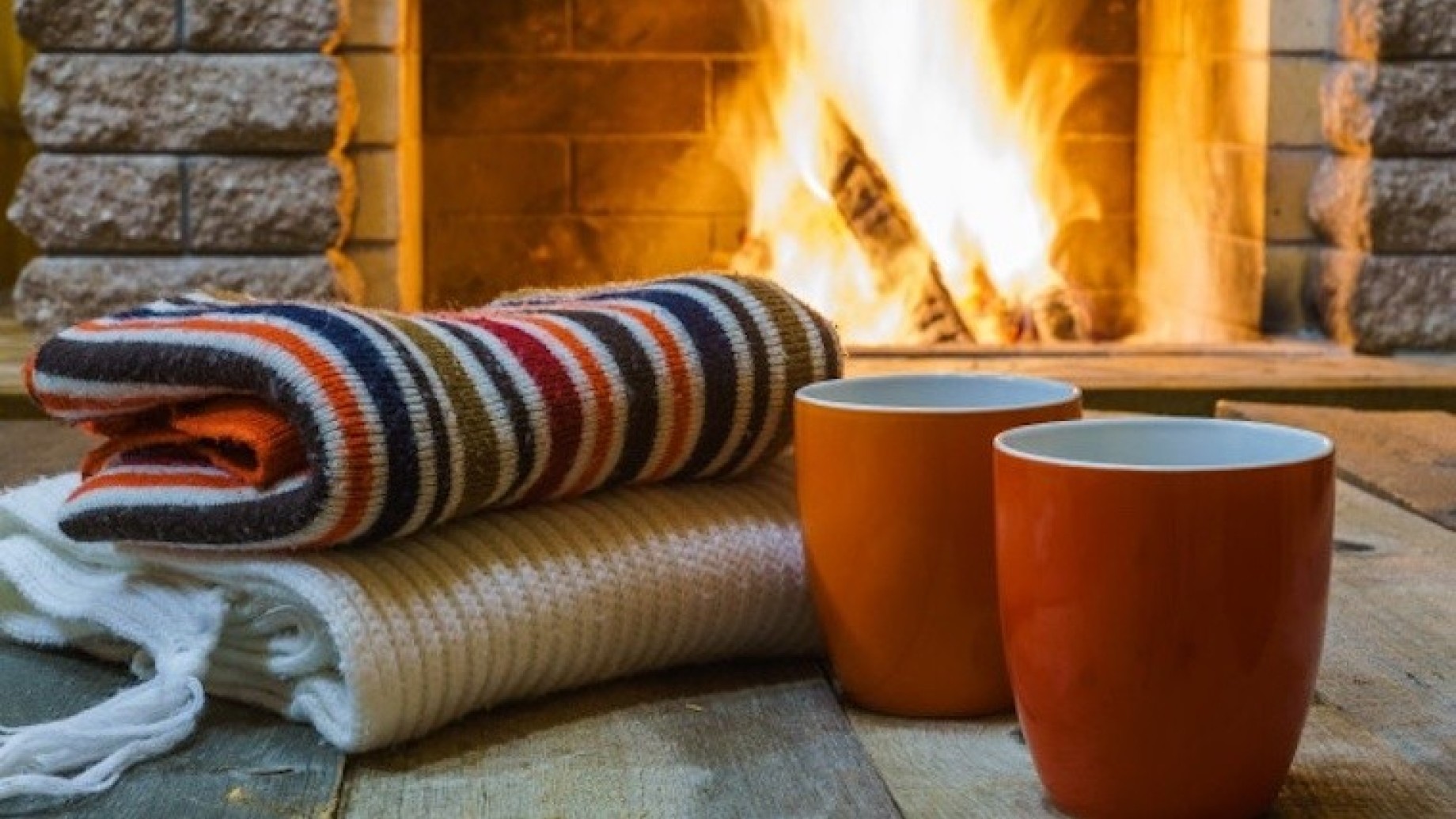 dos-tazas-te-o-cafe-cosas-lana-cerca-chimenea-acogedora-casa-campo-vacaciones-invierno_73966-707